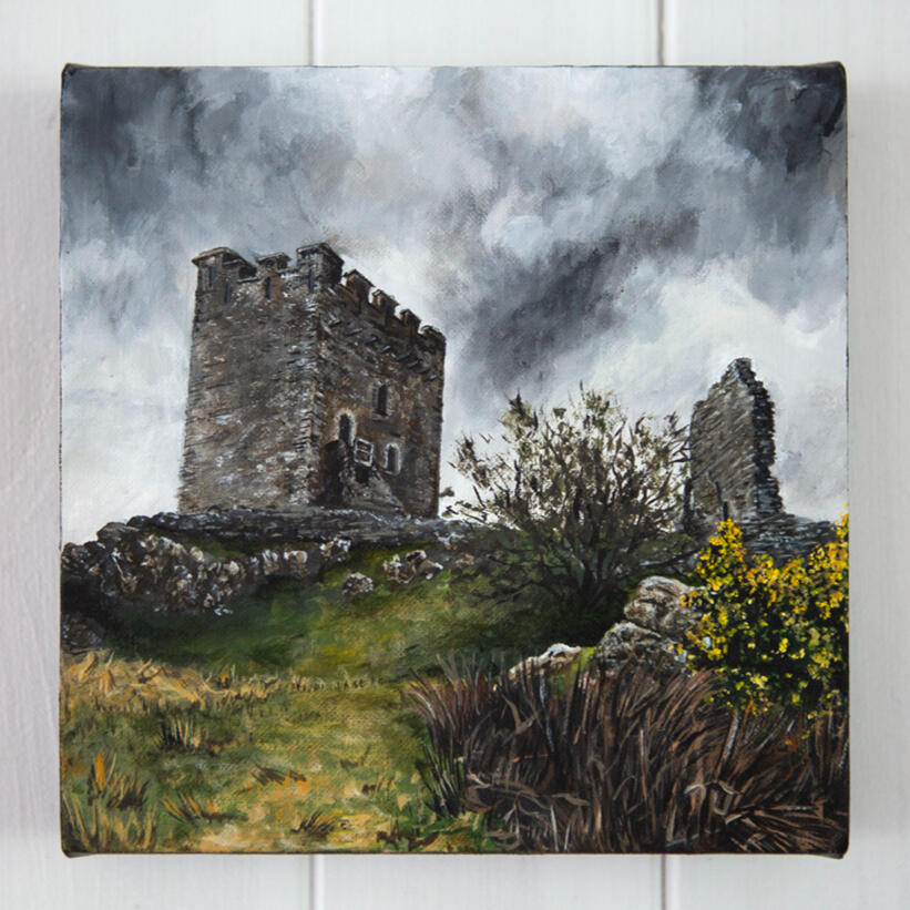 Atmospheric painting of a medieval stone castle ruin on a grassy hillside, featuring a tall square tower with battlements, a crumbling wall, flowering yellow gorse bushes, and dramatic storm clouds filling the sky.